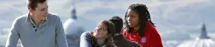 Three students chatting on Carlton Hill overlooking the city of Edinburgh