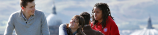 Three students chatting on Carlton Hill overlooking the city of Edinburgh